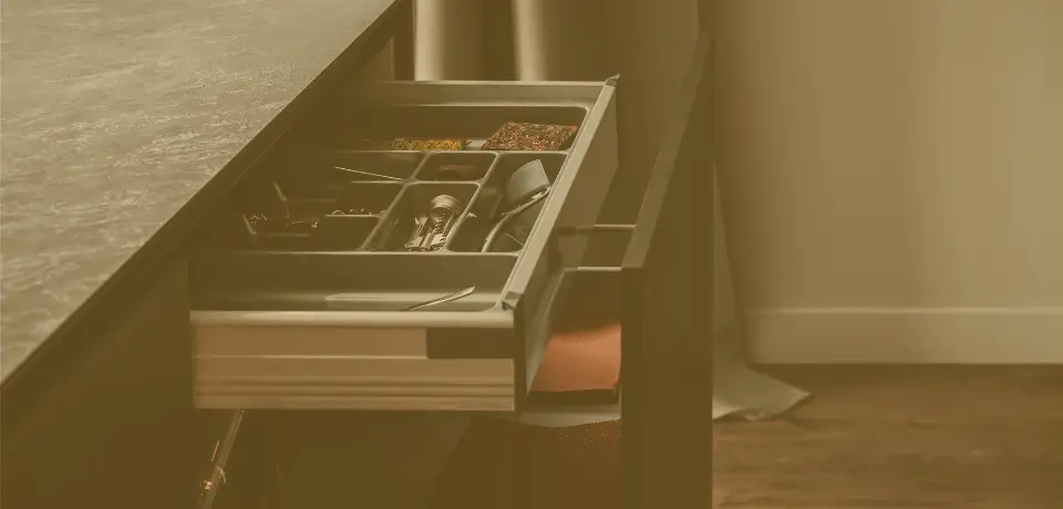 detaliu mobila de bucatarie, sub blatul gri de compozit, sertar in sertar deschis, metalic cu accesorii premium si tacamuri